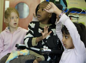 Classroom view of a boy in a wheelchair with a white girl and an Asian girl